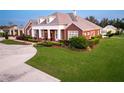 Brick home with landscaping, driveway, and partial view of pool at 2780 Vickie Ct, Kissimmee, FL 34744