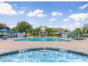 Community pool and spa area with lounge chairs and umbrellas at 2280 San Vital Dr # 105, Kissimmee, FL 34741