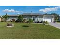 Cute ranch home with a well-maintained lawn and a two-car garage at 1395 Emerald Dr, Kissimmee, FL 34744