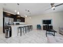 Open floor plan with kitchen island, stainless steel appliances, and living area with comfortable seating at 8930 Stinger Dr, Davenport, FL 33896