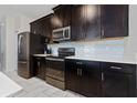 Modern kitchen with dark cabinets and quartz counters at 8930 Stinger Dr, Davenport, FL 33896