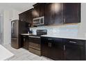 Modern kitchen with dark cabinetry and stainless steel appliances at 8932 Stinger Dr, Davenport, FL 33896
