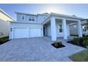 Two-story house with light gray siding and white garage doors at 13193 Tollcross Way, Winter Garden, FL 34787