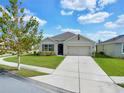 One story house with a two-car garage and a tree in front at 353 Summershore Dr, Auburndale, FL 33823