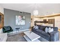 Open living room, featuring a stylish couch, accent chair, and a view of the kitchen at 4751 Clock Tower Dr # 107, Kissimmee, FL 34746