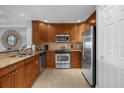 Modern kitchen with wood cabinets and granite countertops at 7662 Whisper Way # 402, Reunion, FL 34747