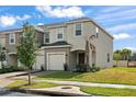 Two-story townhome with a tan exterior, two-car garage and landscaping at 3550 Davenport Creek Ct, Kissimmee, FL 34746