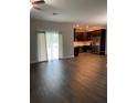 Open living room with vinyl flooring, access to the kitchen, and a sliding glass door at 221 Elm Ct, Poinciana, FL 34759