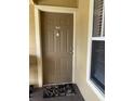 Condo entry with brown door, window, and floral doormat at 2206 E Antigua Pl # 1033, Kissimmee, FL 34741