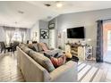 Spacious living room with sectional sofa, large TV, and adjacent dining area at 270 Earlmont Pl, Davenport, FL 33896