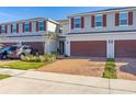 Two-story townhome with a two-car garage and landscaped yard at 4919 Conifer Cone Dr, Kissimmee, FL 34746