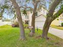 House exterior with mature trees and landscaping at 632 Pinewood Dr, Davenport, FL 33896