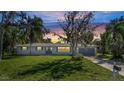 Charming single story home with a gray garage door, well-manicured lawn, and beautiful sunset at 905 Valencia Rd, South Daytona, FL 32119