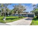 Single story home with a gray garage door, and a spacious yard at 905 Valencia Rd, South Daytona, FL 32119