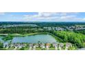 Houses near a lake with mature trees and a park at 973 Lake Berkley Dr, Kissimmee, FL 34746