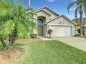 One-story house with attached garage and tropical landscaping at 973 Lake Berkley Dr, Kissimmee, FL 34746