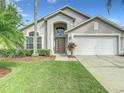 Two-story house with a two-car garage, landscaping, and a green lawn at 973 Lake Berkley Dr, Kissimmee, FL 34746