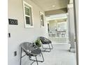 Covered front porch with gray floor and two wicker chairs at 1608 Cross Prairie Pkwy, Kissimmee, FL 34744