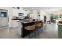 Modern kitchen with island, granite countertops, and stainless steel appliances at 6883 Botanic Blvd, Harmony, FL 34773