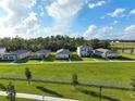 Row of houses with green lawns and white fence at 6883 Botanic Blvd, Harmony, FL 34773