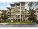 Three-story building with screened balconies and lush landscaping at 9051 Treasure Trove Ln # 307, Kissimmee, FL 34747