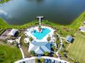 Community pool with a waterslide, adjacent to a lake and playground at 4963 Royal Point Ave, Kissimmee, FL 34746