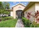 Inviting exterior with landscaped walkway leading to a screened entryway at 540 Genoa Dr, Poinciana, FL 34759