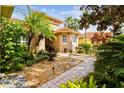 Landscaped front yard with a brick pathway and water fountain at 561 Sienna Dr, Poinciana, FL 34759