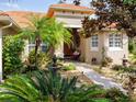 Welcoming front entry with lush landscaping and a charming fountain at 561 Sienna Dr, Poinciana, FL 34759