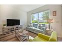 Bright living room featuring a comfy couch, large TV, and hardwood floors at 709 Benoi Dr, Davenport, FL 33896