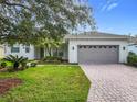 White house with a gray garage door and landscaping at 759 Largo Pass, Kissimmee, FL 34759