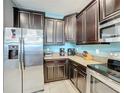 Kitchen with dark cabinets and stainless steel appliances at 9158 Wedge Dr, Davenport, FL 33896