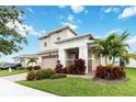 Two-story house with a two-car garage and tropical landscaping at 5075 Twin Lakes Blvd, St Cloud, FL 34772
