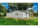 Gray house with a grassy lawn and mature trees in the background at 639 Shore Acres Dr, Lakeland, FL 33801