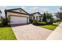 One-story house with a white garage door and lush landscaping at 7845 Wandering Way, Orlando, FL 32836