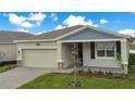 One-story house with gray siding, a two-car garage, and a landscaped yard at 2971 Camden Way, Davenport, FL 33837