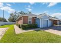Front view of a light blue and brick home with garage at 3401 Home Town Ln, St Cloud, FL 34769