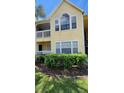 Condo building exterior with a yellow facade and lush landscaping at 1025 S Hiawassee Rd # 2216, Orlando, FL 32835
