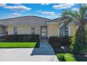 Front view of a villa with a red door and green lawn at 2216 Mystic Ring Loop, Poinciana, FL 34759