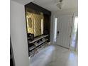 Elegant entryway with a geometric mirror, console table, and marble flooring at 2737 Nottel Dr, Saint Cloud, FL 34772