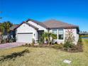 Single-story house with gray siding, landscaping, and a two-car garage at 445 Via Abruzzi St, Poinciana, FL 34759