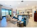 Open living space with a teal couch, kitchen island view, and sliding door access to the outdoors at 445 Via Abruzzi St, Poinciana, FL 34759