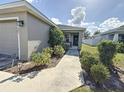 Front entry with walkway, landscaping, and a two-car garage at 502 Pentas Ln, Haines City, FL 33844