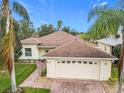 House exterior showcasing a two-car garage and well-maintained lawn at 141 Marabella Loop, Poinciana, FL 34759