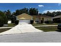 House exterior with a two-car garage and a spacious driveway at 481 Peppermill Cir, Kissimmee, FL 34758