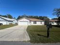 Cute one-story home with a large driveway and well-maintained lawn at 824 San Pedro Ct, Kissimmee, FL 34758