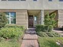 Townhome entrance with brick walkway and lush landscaping at 10090 Sunnifa Aly, Orlando, FL 32832