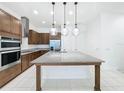 Spacious kitchen with island, stainless steel appliances, and granite counters at 10090 Sunnifa Aly, Orlando, FL 32832