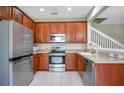 Galley kitchen with wood cabinets, stainless steel appliances, and granite countertops at 1060 Rock Harbor Ave, Orlando, FL 32828
