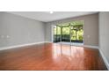 Bright living room with hardwood floors and sliding glass doors leading to a screened patio at 1060 Rock Harbor Ave, Orlando, FL 32828